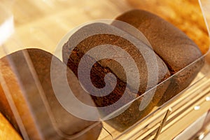 Loaves of black bread on a wooden counter in a store. Close-up