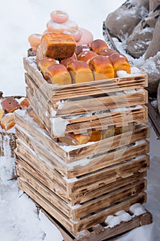 Loaves of bread in wooden pallets in the snow.