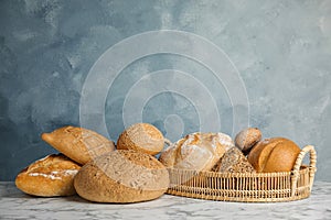 Loaves of different breads on marble table