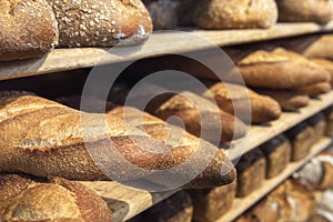 Loaves on wooden shelves. Fresh baked goods. Healthy bread