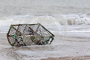 Lobster creel washed up on the beach. Crab pot fishing basket