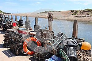 Lobster pots and other various pieces of fishing equipment piled up by the river Axe at Axmouth