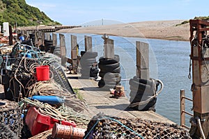 Lobster pots and other various pieces of fishing equipment piled up by the river Axe at Axmouth