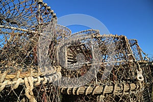 Lobster pots stacked up against blue sky