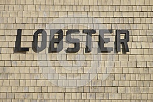 Lobster sign on a clapboard commercial structure at a new England working dock