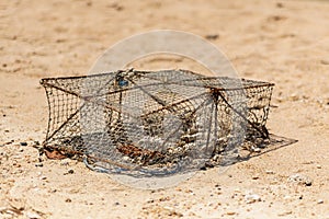 Lobster trap old and rusty rectangular container traditional hunting on sand background