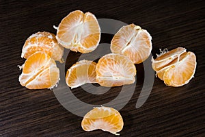 Lobules of mandarin on dark wooden table