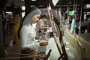 Local Amarapura woman weaving hand-made tradional myanmar fabric at weaving factoryin Mandalay Myanmar