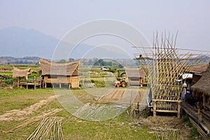 Local architectural house with unique roof design and under construction bamboo structure in foreground mountain in background