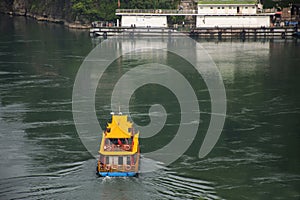 Local boat cruise or ship ferry send receive chinese people passengers foreign travelers crossing yangtze or Chang Jiang river in photo