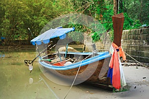 A local colorful fishing boat moored at the shore on the sea beach