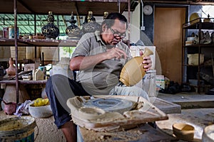 Local craftsman demonstrates on making traditional clay jar called