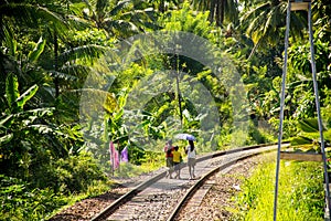 Local family in sri lanka walking on railway tracks