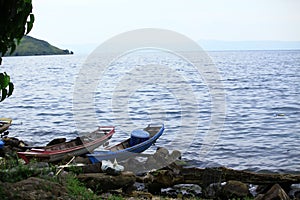 Local fishermen boats were harbored in the rocky beach in Toba Lake, North Sumatra, Indonesia