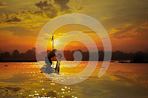 Local fishermen set sail in the morning sunlight reflecting off sky