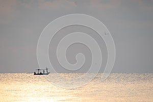 Local fishing boat on the sea with sunrise scene.