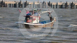 Local fishing boats anchor amid strong waves at Wannapha Beach, Bang Saen