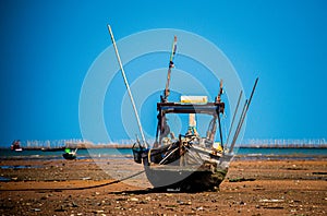 Local fishing boats run aground during low tide in front of Ban Na Kluea Bay, Chon Buri Province, Thailand