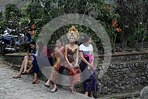 A  local girl with an ornate gold head-dress waits for the  annual Perang Pandan festival to
