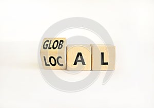 Local or global symbol. Businessman turns wooden cubes and changes the word Local to Global. Beautiful white table white
