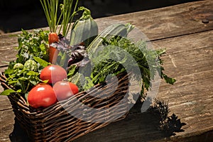 Local grown, farm vegetables in a basket on a wooden brown table