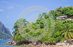 Local hut on seacoast. Traditional cabin in tropical jungle near the sea. Tropical landscape with rural bungalow.