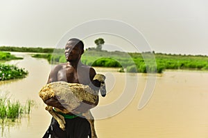 A local man poss with is ram backing  a river.