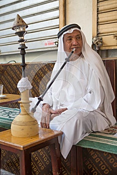 local man smoking shisha early in the morning at a cafe in dubai