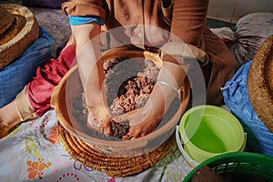 Local Moroccan woman hand-kneading argan oily paste to extract Argan oil.