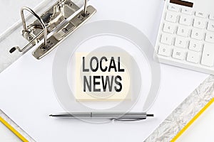 LOCAL NEWS - business concept, message on the sticker on folder background with calculator