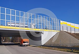 Local road, passage under the highway. Highway surrounded by sound absorbing barriers