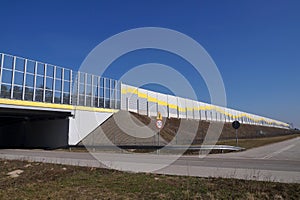 Local road, passage under the highway. Highway surrounded by sound absorbing barriers