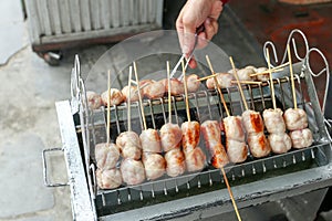 Local seller cook Northeast Thai style meat sausage at Bangrak market, Bangkok, Thailand