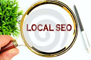 LOCAL SEO text written through a magnifying glass on a white background