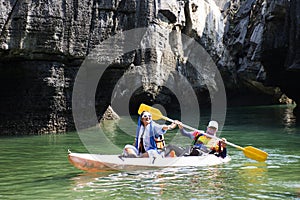 Local thai people guide paddle canoe boat of trip tour in sea ocean bring travelers women travel visit Prasat Hin Pan Yod in Mu Ko