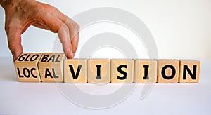 From local to global vision. Businessman turns cubes and changes words `local vision` to `global vision`. Beautiful white