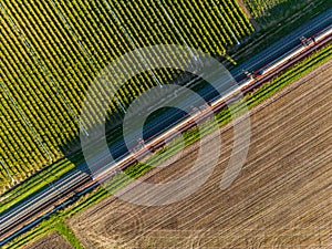 A local train between field and field seen directly from above with the drone