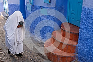 Local woman in white cloak in the city of  Chefchaouen,Morocco