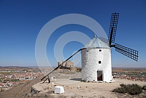 White Windmill and castle on hill in Consuegra, Spain photo