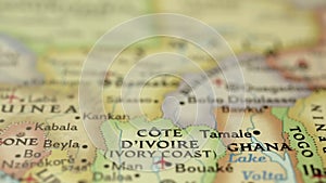 Location Ivory Coast or Cote D'IVOIRE, Africa on travel map, man hand push pin close-up