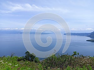 the location of the view of Lake Toba and lake water is clean and blue from the top of the hill