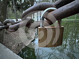 The lock is attached to a rusty chain. A small padlock is attached to the chain. Concept: love is eternal, we are inseparable photo