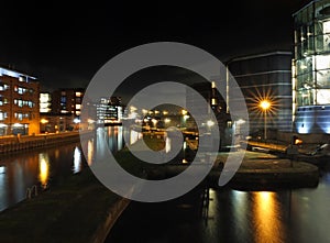 Clarence dock in leeds at night with buildings of the city reflected in the water photo