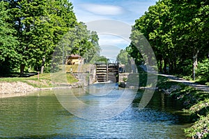 Sea lock at Gota canal in Sweden, with green trees along the riv photo