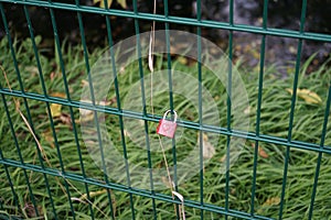 A lock with a heart hangs on a fence by the river, where the keys are thrown away as a symbol of eternal love. Berlin, Germany