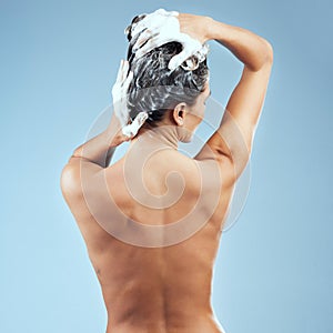 Lock in moisture and drench your strands in nutrients. Studio shot of an attractive young woman washing her hair while