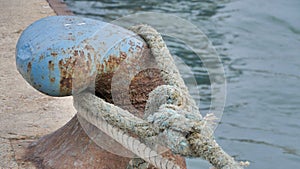 Lock mooring mechanism. Enlarged image of a large blue metal hook with a giant marine cable for towing ships. Focus on