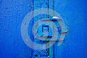 Lock on old iron door with a shabby bright blue paint, grunge background