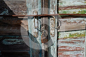 Lock on an old wooden door with rusty inserts