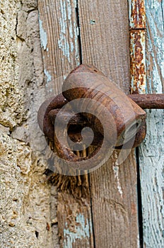 Lock on an old wooden door with rusty inserts